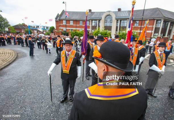 Members of an Orange Order gather ahead of parades in west Belfast on July 12 which take place across Northern Ireland to celebrate the battle of the...