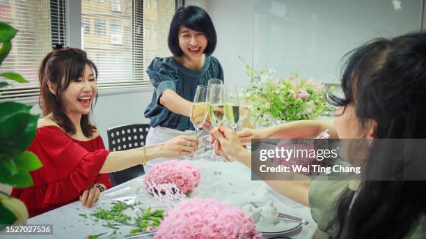 美しいアジアの女性たちは、フラワーアートのクラスに参加し、花をアレンジしたり、シャンパンを飲んだりしながら、笑顔で女性の会話の瞬間を大切にしながら、一緒に時間を楽しんでい� - flower arrangement carnation ストックフォトと画像