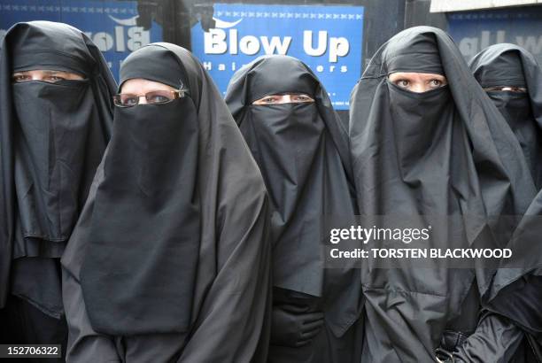 Men and women dressed in burqas from the group 'Faceless' call for the banning of the conservative Muslim apparel throughout Australia during a rally...