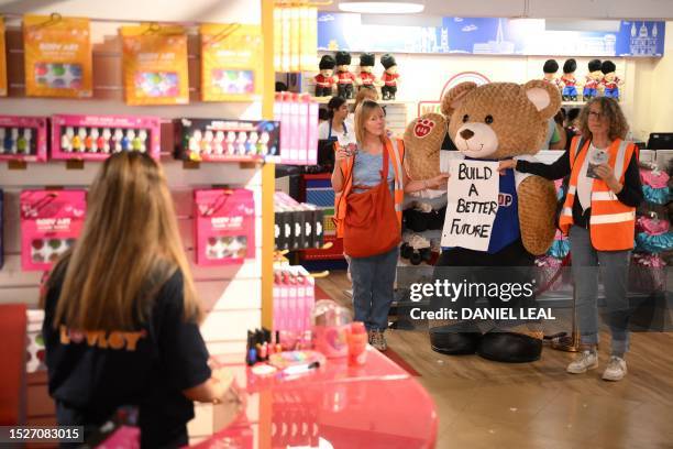 Climate change activists from Just Stop Oil hold placards as they demonstrate inside Hamleys toy shop on Regent Street in London on July 12, 2023.