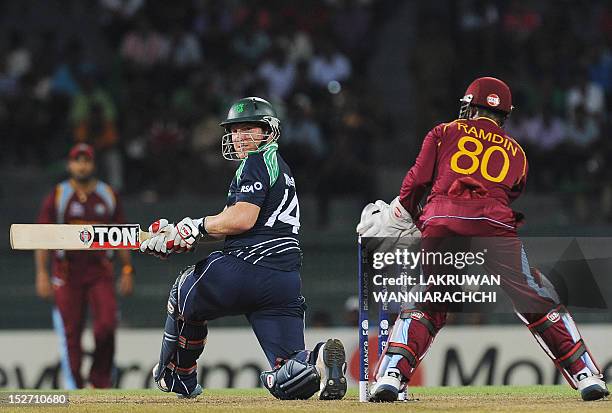 Ireland cricketer Gary Wilson plays a shot as West Indies wicketkeeper Denesh Ramdin looks on during the ICC Twenty20 Cricket World Cup match between...