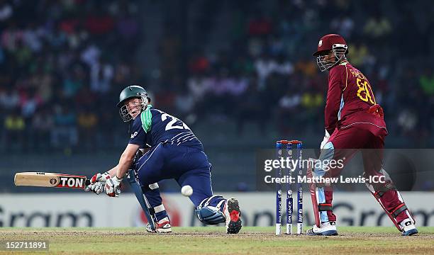 Kevin O'Brien of Ireland sweeps the ball, as Denesh Ramdin of the West Indies looks on during the ICC World Twenty20 2012 Group B match between West...