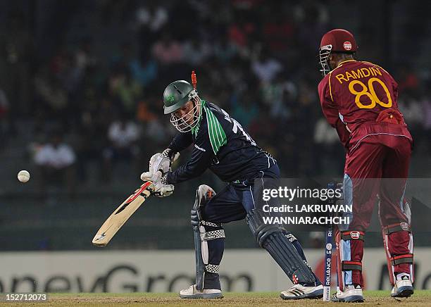 Ireland cricketer Niall O'Brien gets dismissed by unseen West Indies cricketer Chris Gayle as wicketkeeper Denesh Ramdin looks on during the ICC...