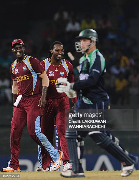 West Indies cricketer Chris Gayle celebrates with his captain Darren Sammy after he dismissed Ireland cricketer Niall O'Brien during the ICC Twenty20...