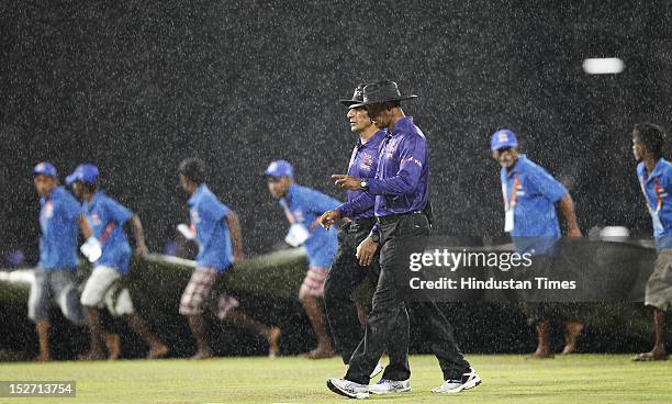 Both the umpires leave the ground as rain stops the game during the ICC T20 World Cup cricket match between West Indies and Ireland at R. Premadasa...