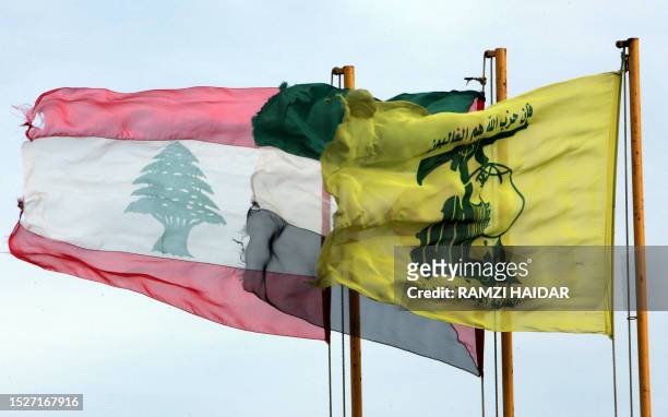 Hezbollah flag flutters beside Palestinian and Lebanese flags in the Lebanese southern village of Hula, 20 February 2007 on the border with Israel....