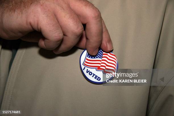 Man places an "I Voted" sticker on his coat after casting his ballot 07 November 2006 at the Sudley North Government Center in Prince William County,...