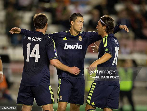 Real Madrid's Portuguese forward Cristiano Ronaldo celebrates with teammates Real Madrid's midfielder Xabi Alonso and Real Madrid's German midfielder...