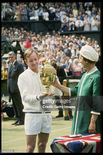 Rod Laver of Australia is handed the Wimbledon mens singles trophy by Queen Elizabeth II after winning the title at the all England club in London....