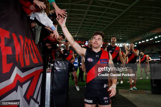 Zach Merrett of the Bombers leads the team off the field after winning the round 17 AFL match between Essendon Bombers and Adelaide Crows at Marvel...