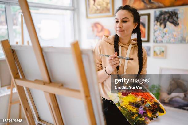 young talented female painter enjoying while painting in art studio - art class stock pictures, royalty-free photos & images