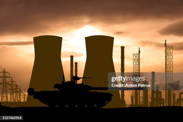 armored tank on the background of a nuclear power plant - burst pipes stock pictures, royalty-free photos & images