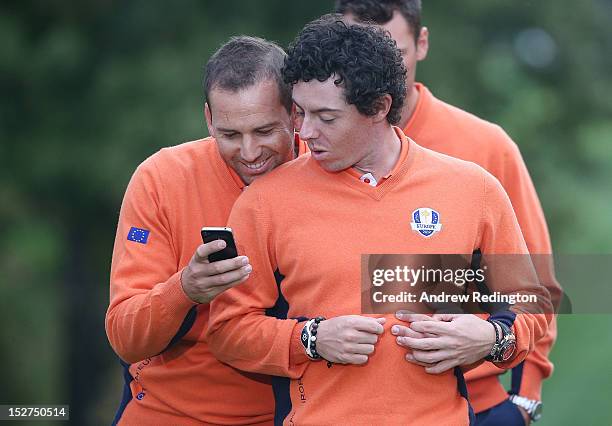 Sergio Garcia and Rory McIlroy of Europe check out a smart phone during a photo call during the second preview day of The 39th Ryder Cup at Medinah...