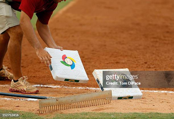 Member of the grounds crew replaces first base game 6 of the Qualifying Round of the World Baseball Classic at Roger Dean Stadium between Team Israel...