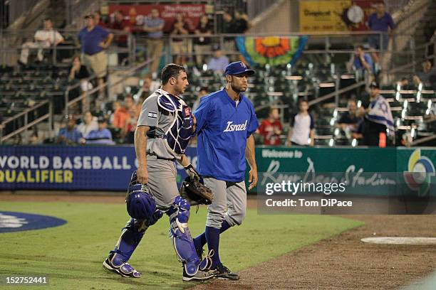 Charles Cutler of Team Israel is walked off the field by Gabe Kapler of Team Israel game 6 of the Qualifying Round of the World Baseball Classic at...