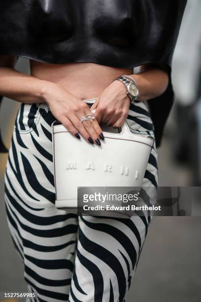 Guest wears a black shiny leather embossed chest / shoulder-pads / short sleeves / cropped top, white and black zebra print pattern large pants, a...