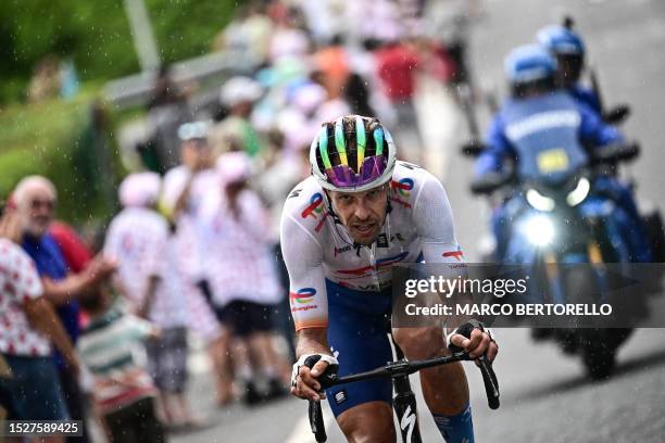 TotalEnergies' Italian rider Daniel Oss cycles in the rain, in a lone breakaway ahead of the pack of riders during the 11th stage of the 110th...