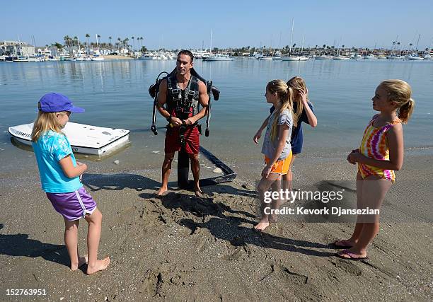 Stella Robson her sister Hanna Robson twins sisters Ani Burns, 10 and Jennifer Burns look on as Dean O'Malley demonstrates a JetLev, a water-powered...