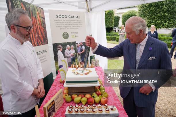 Britain's King Charles III cuts a cake to celebrate four decades of the Prince of Wales's Charitable Fund, with Waitrose senior chef Will Torrent,...