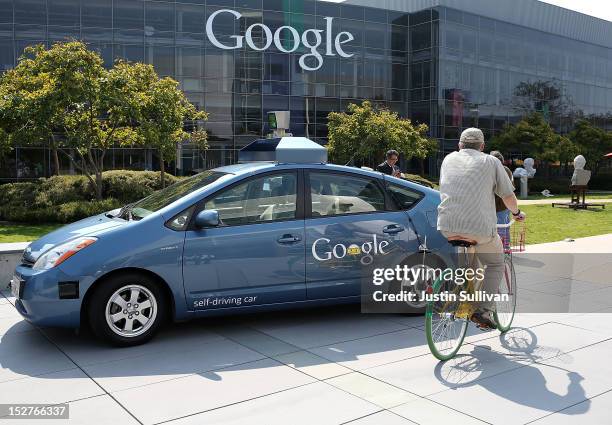 Bicyclist rides by a Google self-driving car at the Google headquarters on September 25, 2012 in Mountain View, California. California Gov. Jerry...