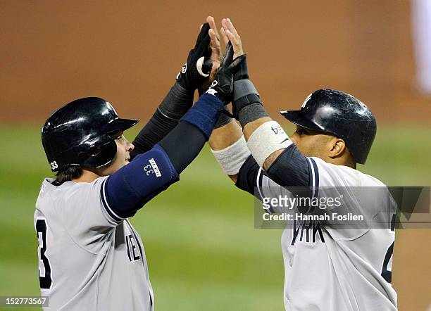 Robinson Cano of the New York Yankees congratulates Nick Swisher on a two run home run against the Minnesota Twins during the fourth inning of the...