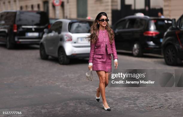Camilla Coelho seen outside Chanel show wearing black headband, pink colored tweed suit jacket with matching skirt, pearl Chanel handbag and crystal...