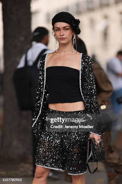 Melanie Kieback seen outside Chanel show wearing black barret, crystal earrings, black bandeau top, glittery Chanel jacket and matching skirt,...