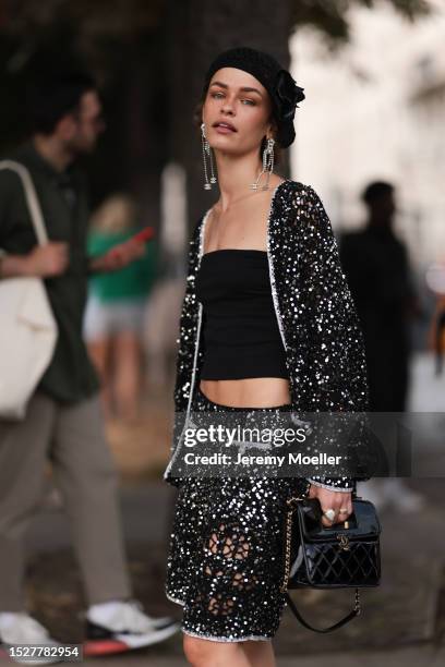 Melanie Kieback seen outside Chanel show wearing black barret, crystal earrings, black bandeau top, glittery Chanel jacket and matching skirt,...