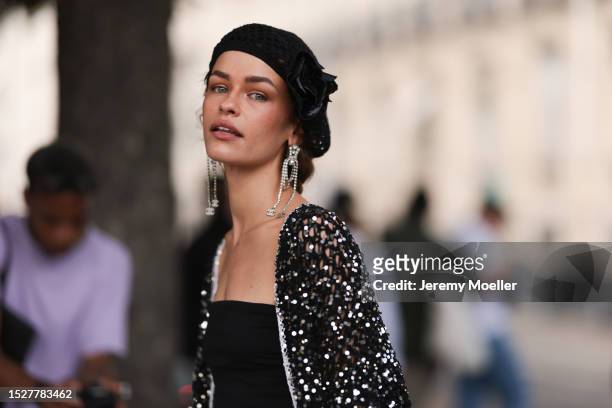 Melanie Kieback seen outside Chanel show wearing black barret, crystal earrings, black bandeau top, glittery Chanel jacket and matching skirt,...