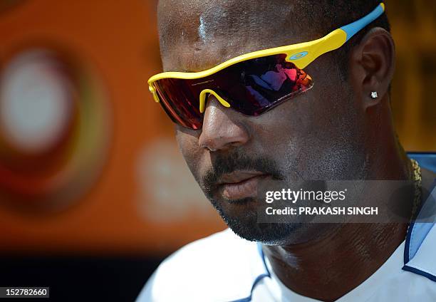 West Indies cricketer Dwayne Smith rests during an ICC Twenty20 Cricket World Cup practice session at the Pallekele International Cricket Stadium in...