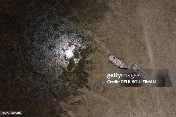 In this aerial picture, fishing boats are stranded on the banks of the Euphrates river in low water levels, near the village of Tawayhinah in Syria's...
