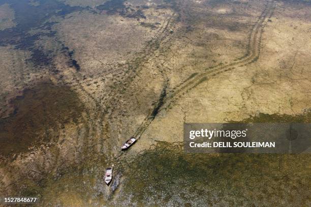In this aerial picture, fishing boats are stranded on the banks of the Euphrates river in low water levels, near the village of Tawayhinah in Syria's...