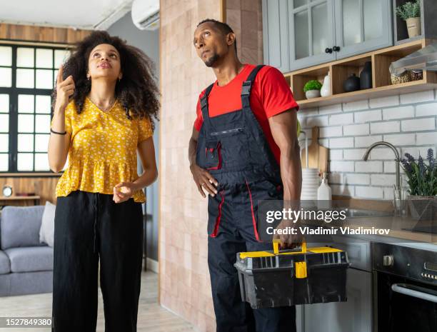 a housewife showing a workman the repairs she needs in her kitchen - customer needs stock pictures, royalty-free photos & images