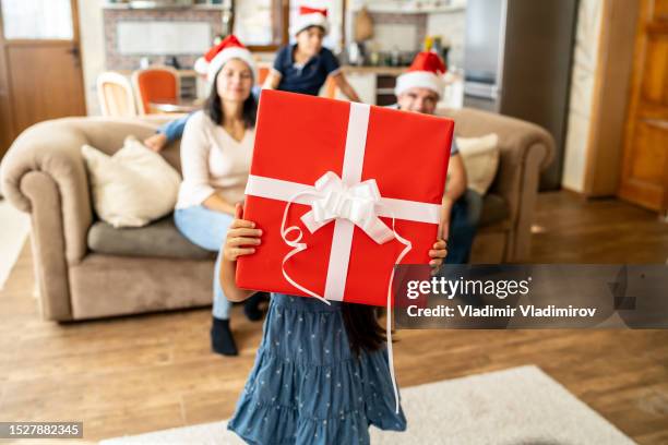 a child holding a christmas present - unusual christmas stock pictures, royalty-free photos & images