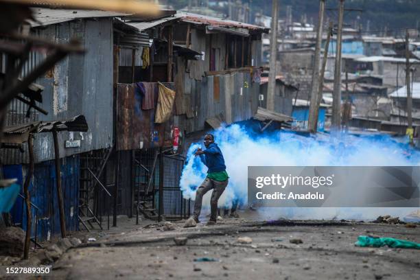 Demonstrator, protesting tax increases, throws back tear gas to the police in Nairobi, Kenya on July 12, 2023.