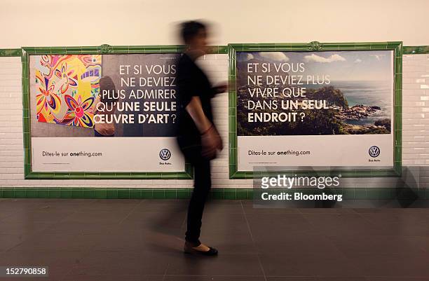Pedestrian passes a set of Volkswagen AG adverts inside the Portes de Versailles Metro station ahead of the opening day of the Paris Motor Show in...