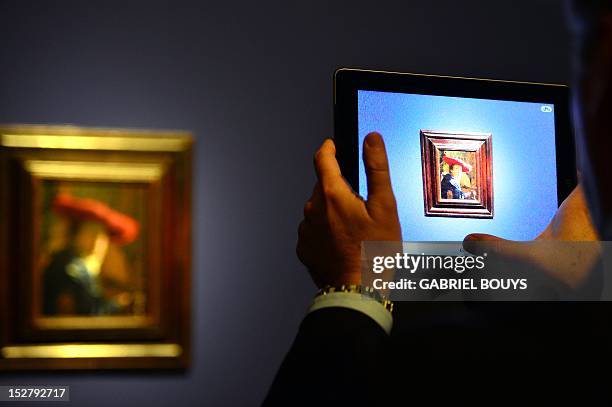 Visitor takes a picture of "Girl with the Red Hat" by Dutch artist Johannes Vermeer on September 26, 2012 during the media preview of the exhibition...