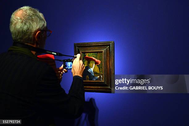 Visitor takes a picture of "Girl with the Red Hat" by Dutch artist Johannes Vermeer on September 26, 2012 during the media preview of the exhibition...