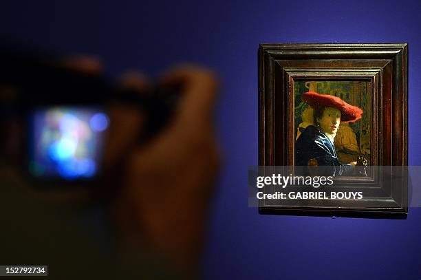 Visitor takes a picture of "Girl with the Red Hat" by Dutch artist Johannes Vermeer on September 26, 2012 during the media preview of the exhibition...