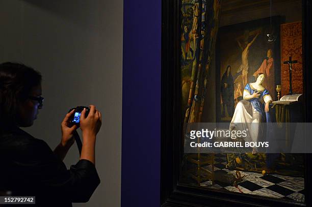 Visitor takes a picture of "The Allegory of the Catholic Faith" by Dutch artist Johannes Vermeer on September 26, 2012 during the media preview of...