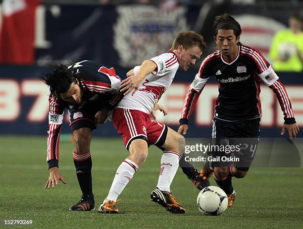Juan Toja and Lee Nguyen of the New England Revolution try to keep the ball from Dax McCarty of the New York Red Bulls at Gillette Stadium September...