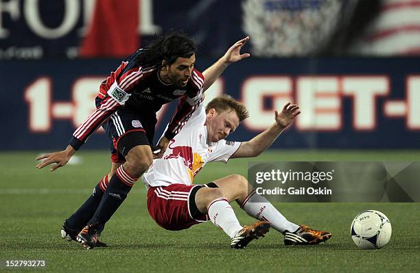 Juan Toja of the New England Revolution tries to keep the ball from Dax McCarty of the New York Red Bulls at Gillette Stadium September 22, 2012 in...