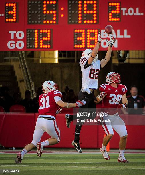 Wide receiver Luke Austin of the Idaho State Bengals reaches for a pass over cornerback Jase Dean and safety Justin Blatchford of the Nebraska...