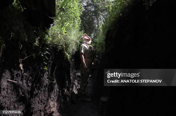 Ukrainian serviceman from the K-2 battalion looks up from a trench at a frontline position near the town of Siversk, Donetsk region, on July 12 amid...