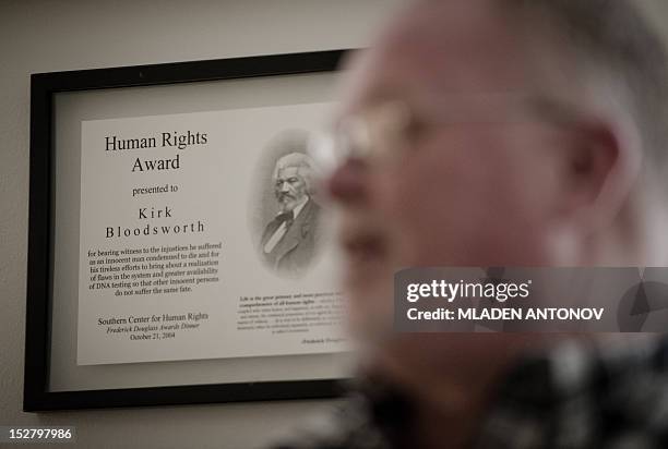 Human Rights award certificate is seen on the wall as Kirk Bloodsworth speaks during an interview with AFP in his apartment in Mount Rainier,...