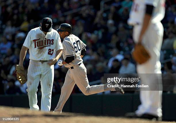 Chris Parmelee and Anthony Swarzak of the Minnesota Twins look on as Chris Dickerson of the New York Yankees rounds the bases after hitting a two-run...