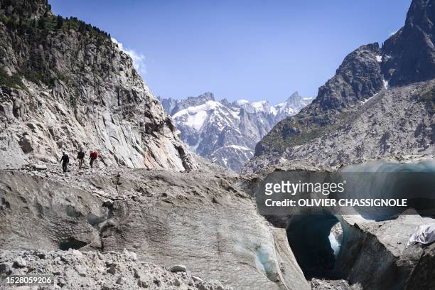 People walk on the Mer de Glace , in Chamonix-Mont-Blanc, in the French Alps on July 11, 2023.