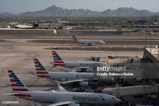 An American Airlines plane taxis past planes at their gates at Sky Harbor International Airport on July 12, 2023 in Phoenix, Arizona. Tuesday marked...