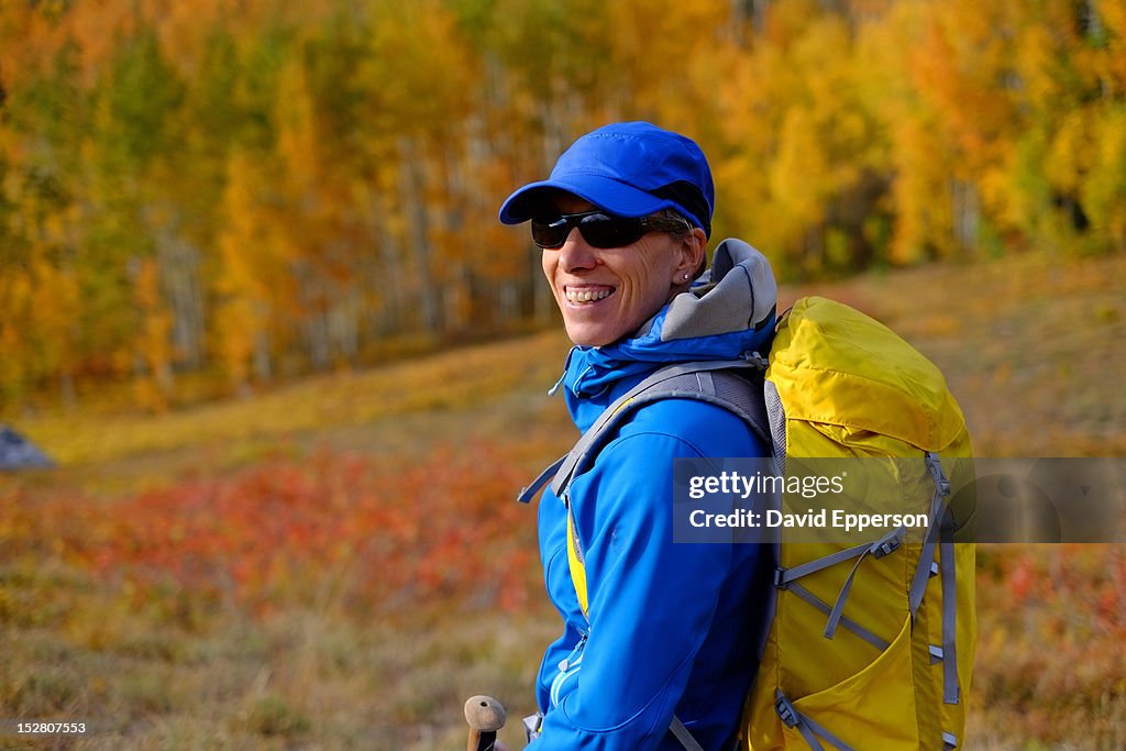 Woman hiking with small pack in fall colors