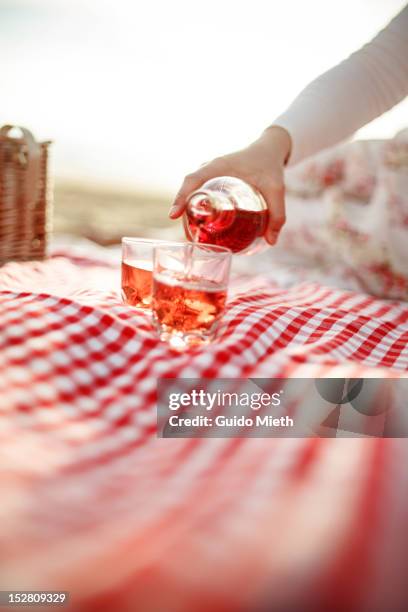 woman pouring glasses rose - single rose stockfoto's en -beelden